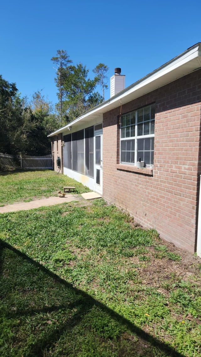 view of yard featuring a sunroom and fence