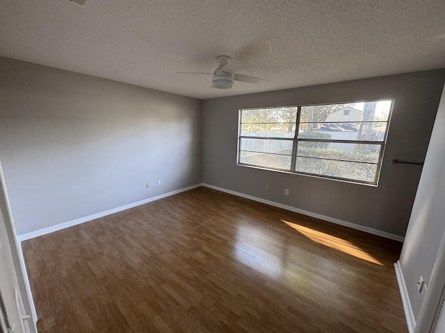 unfurnished room with ceiling fan, dark hardwood / wood-style floors, and a textured ceiling