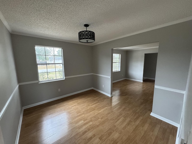 unfurnished room featuring wood-type flooring, a wealth of natural light, and a textured ceiling