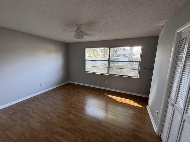 unfurnished bedroom featuring ceiling fan, dark hardwood / wood-style floors, a closet, and a textured ceiling