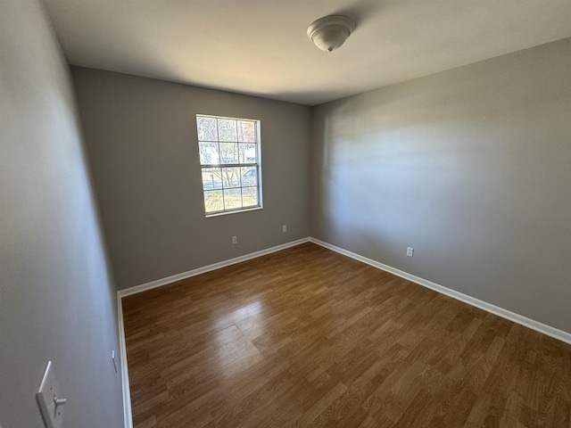 empty room with dark hardwood / wood-style flooring