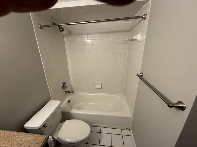 bathroom with tile patterned floors, toilet, and tiled shower / bath