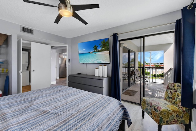 bedroom featuring stainless steel refrigerator, access to exterior, ceiling fan, a textured ceiling, and light wood-type flooring