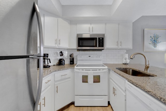 kitchen featuring appliances with stainless steel finishes, light hardwood / wood-style flooring, white cabinetry, and sink