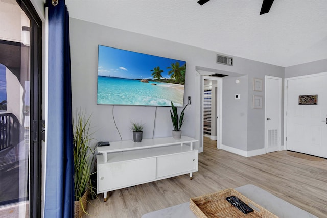 interior space with a textured ceiling and light hardwood / wood-style floors