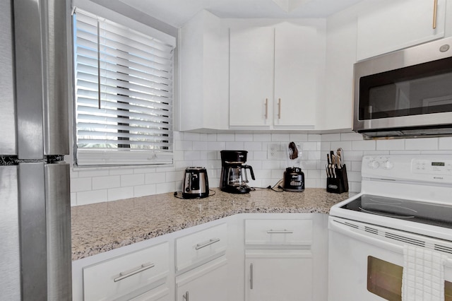 kitchen with tasteful backsplash, light stone counters, white cabinets, and white electric range oven