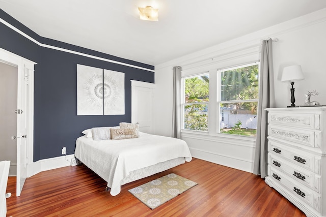 bedroom with dark hardwood / wood-style floors and ornamental molding