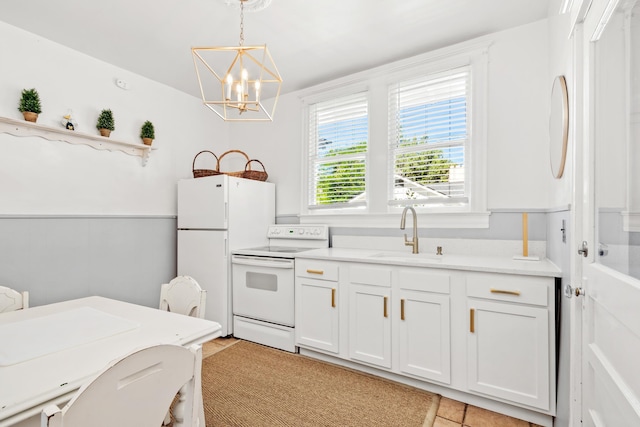 kitchen with white cabinetry, sink, hanging light fixtures, a notable chandelier, and white appliances