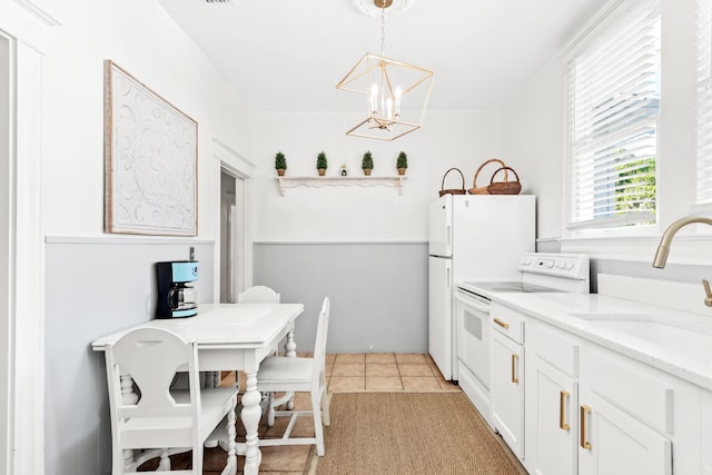 kitchen featuring sink, hanging light fixtures, a notable chandelier, white electric stove, and white cabinets