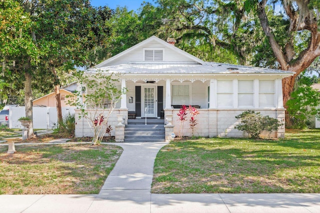 bungalow-style home featuring ceiling fan, a porch, and a front lawn