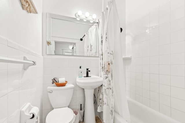 full bathroom featuring toilet, shower / bath combo with shower curtain, and tile walls