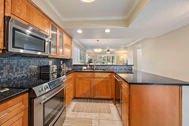 kitchen with sink, stainless steel appliances, kitchen peninsula, a textured ceiling, and light tile patterned floors