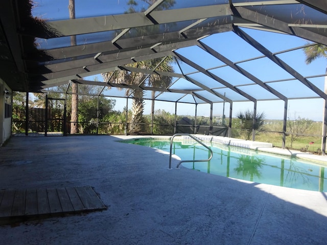 pool with glass enclosure and a patio area