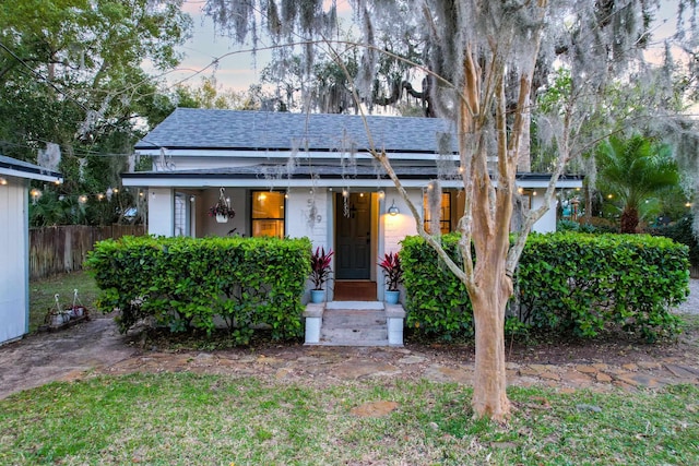 view of front of home featuring fence and roof with shingles