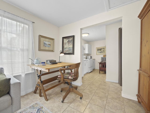 office with baseboards, light tile patterned flooring, and independent washer and dryer