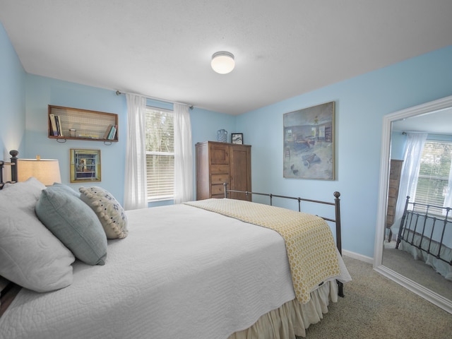 carpeted bedroom featuring baseboards
