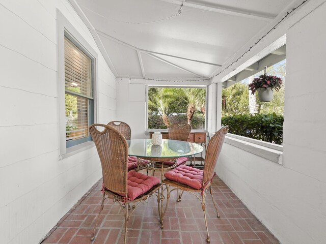 sunroom featuring vaulted ceiling and plenty of natural light