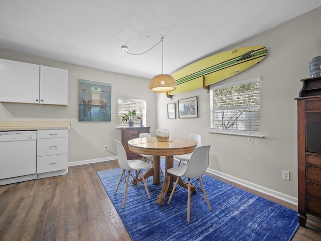 dining space featuring dark wood finished floors and baseboards