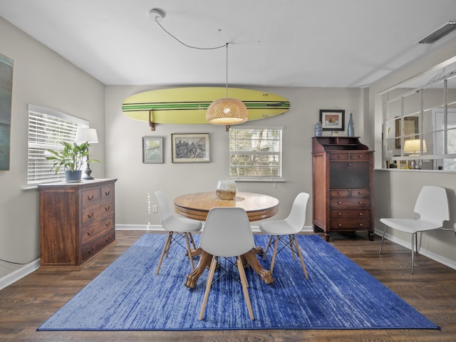 dining room with a healthy amount of sunlight, visible vents, baseboards, and wood finished floors