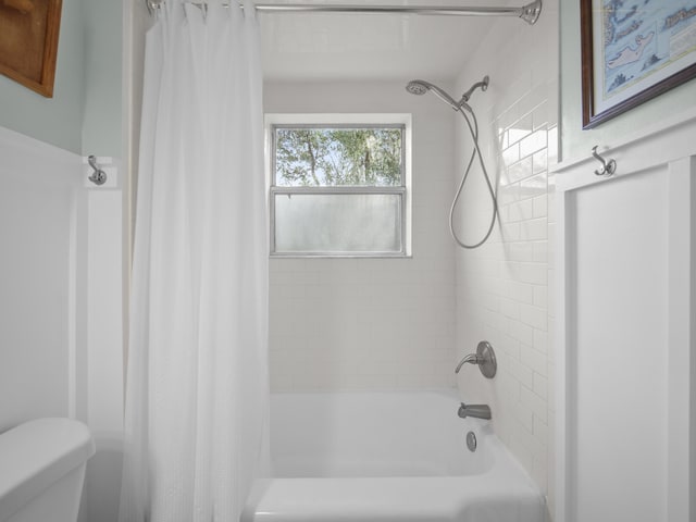 bathroom featuring shower / tub combo with curtain and toilet