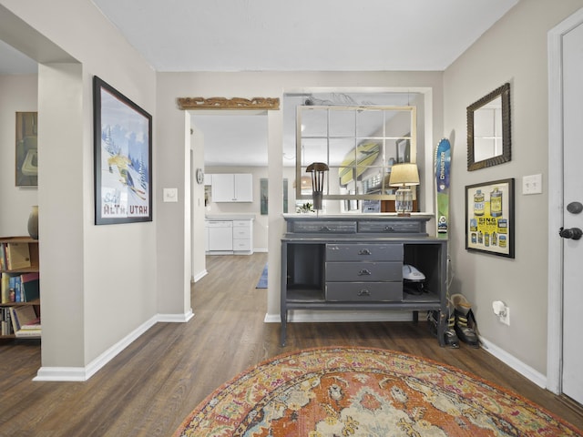 corridor with dark wood-style floors and baseboards