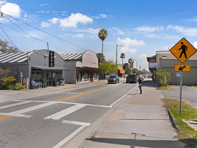 view of road with sidewalks, traffic signs, and curbs