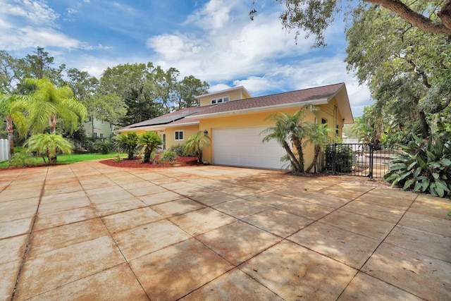 6 Versaggi Pl, Saint Augustine, FL 32080 - view of front facade featuring driveway, roof mounted solar panels, stucco siding, and a garage