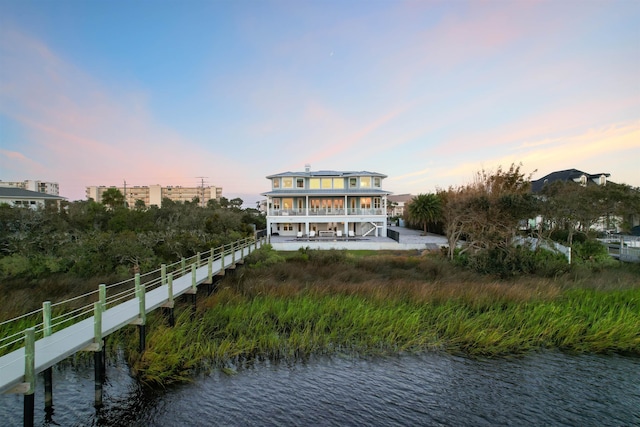 back house at dusk with a water view