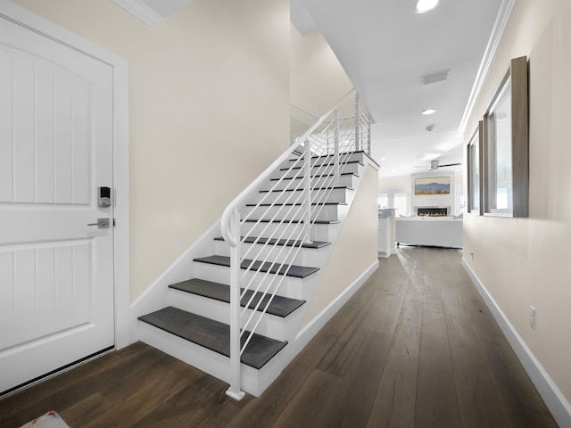 stairs featuring hardwood / wood-style floors and ornamental molding