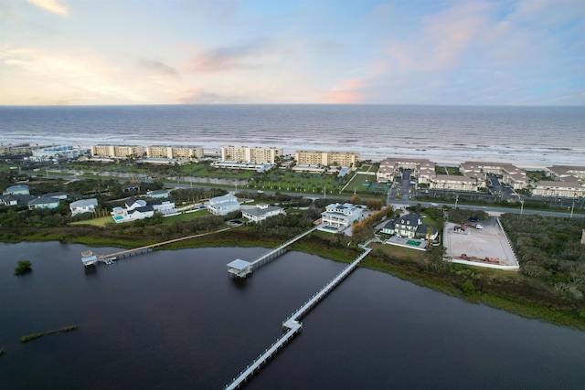 aerial view at dusk featuring a water view