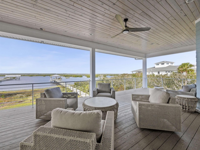 wooden terrace with ceiling fan, a water view, and an outdoor living space