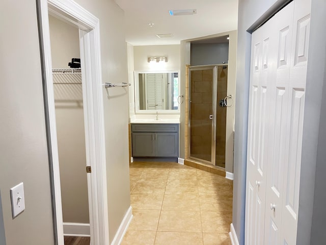 bathroom with tile patterned flooring, vanity, and a shower with shower door