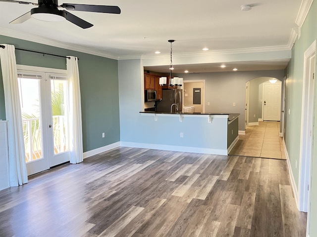 kitchen with ceiling fan, pendant lighting, light wood-type flooring, appliances with stainless steel finishes, and ornamental molding