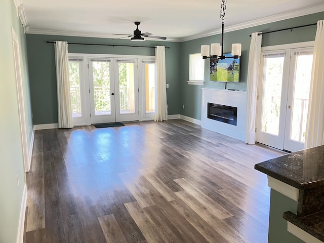 unfurnished living room with french doors, wood-type flooring, ceiling fan with notable chandelier, and ornamental molding