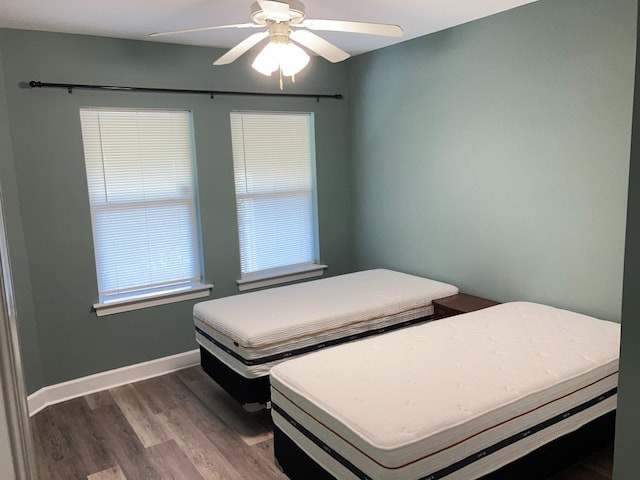 bedroom with dark hardwood / wood-style floors and ceiling fan