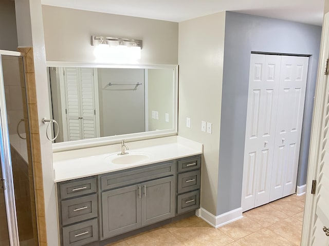 bathroom featuring tile patterned flooring, vanity, and walk in shower