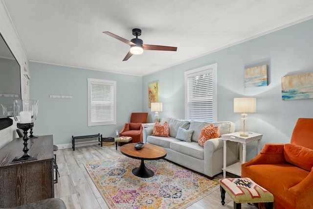 living room featuring light hardwood / wood-style floors, ceiling fan, and crown molding