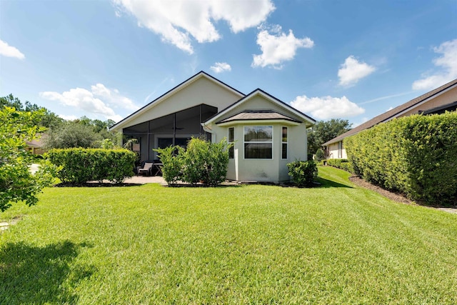 back of house with a lawn and a sunroom