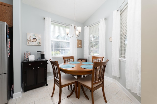 dining area with a notable chandelier, a wealth of natural light, lofted ceiling, and light tile patterned floors