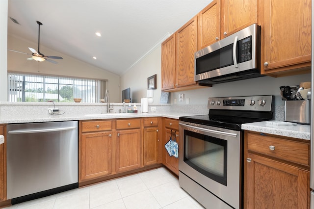 kitchen with stainless steel appliances, ceiling fan, sink, light tile patterned floors, and lofted ceiling