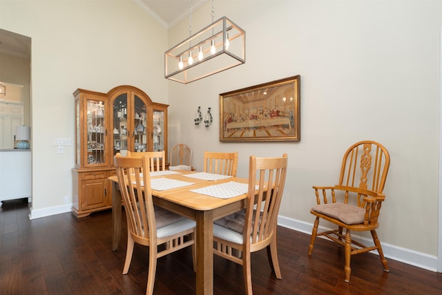 dining area featuring dark hardwood / wood-style flooring, lofted ceiling, and crown molding