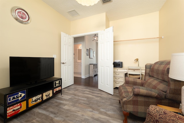 living area with dark hardwood / wood-style flooring and a textured ceiling