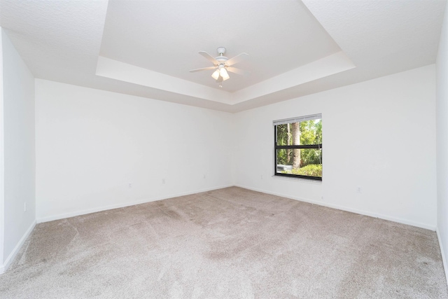 117 Laurel Wood Way Unit 105, Saint Augustine, FL 32086 - empty room featuring a tray ceiling, carpet flooring, a ceiling fan, and baseboards