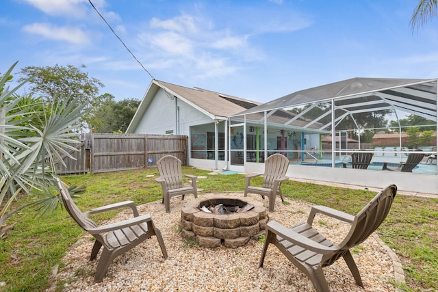 exterior space with a lanai, a lawn, a fenced in pool, and an outdoor fire pit