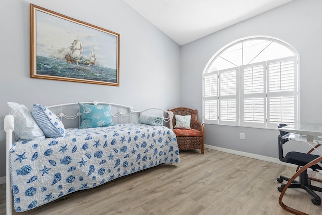 bedroom featuring wood-type flooring and vaulted ceiling