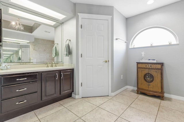 bathroom featuring tile patterned flooring, vanity, and a notable chandelier