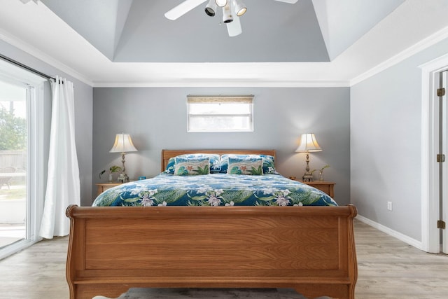 bedroom featuring ceiling fan, a raised ceiling, access to outside, and multiple windows