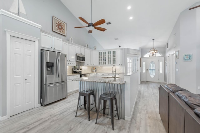 kitchen featuring decorative backsplash, white cabinetry, sink, and appliances with stainless steel finishes