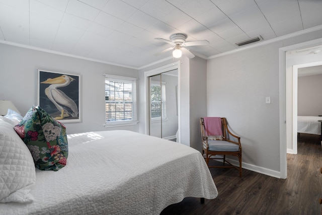 bedroom featuring a closet, ornamental molding, dark hardwood / wood-style floors, and ceiling fan