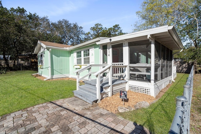 view of front facade featuring a sunroom and a front lawn